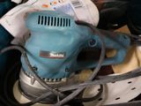 a blue electric sander sitting on top of a table