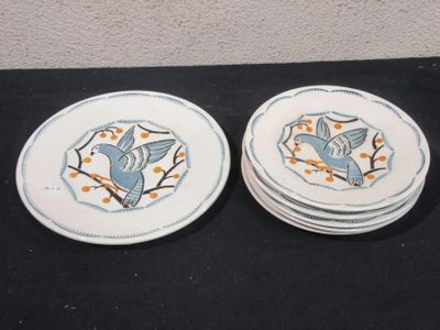 two plates with birds on them sitting on a table