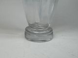 a glass vase with a lid on a white surface