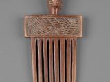 a wooden comb that has a face on it