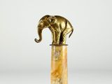 une statue d'éléphant posée sur un socle en marbre, sur fond blanc