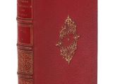 un vieux livre à la couverture rouge et à la bordure dorée