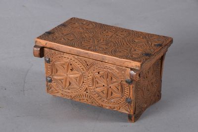 carved wooden box on grey background with metal handles