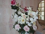 a vase of flowers sitting on a table in a bathroom