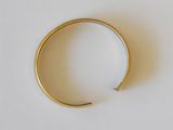 a gold ring on a white surface with a white background