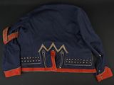 a blue jacket with red and gold trims on a black surface