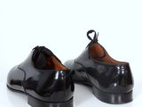 pair of black shoes on a white surface with a white background