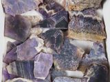 des améthystes violettes dans une boîte blanche posée sur une table