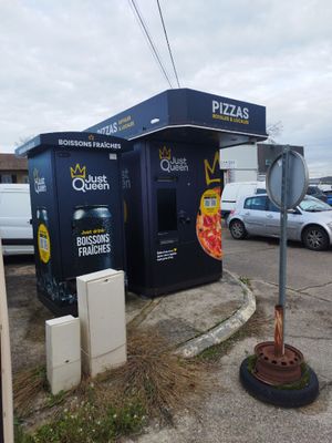 a vending kiosk on the corner of a parking lot