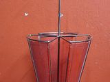 a metal umbrella holder with a metal handle on a table