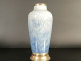 a blue and white vase sitting on a black table