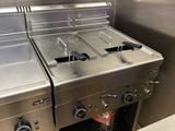 trois cuisinières en acier inoxydable dans une cuisine professionnelle