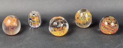 six different colored glass eggs sitting on top of a black surface