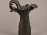 sculpture en bronze représentant un vase en forme de tronc d'arbre sur fond gris