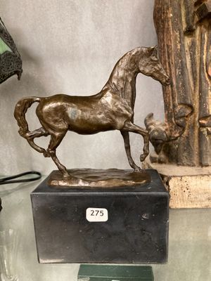 a statue of a horse that is on a glass table
