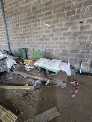 a pile of junk in a room with a brick wall