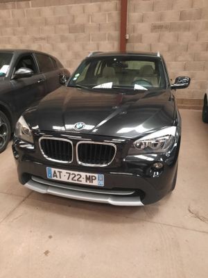 un SUV BMW noir garé dans un parking couvert