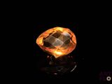 a close up of a yellow diamond on a black surface