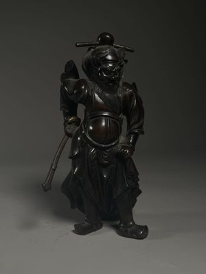bronze figure of a man holding a sword and a bird