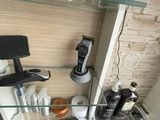 une étagère en verre sur laquelle sont posés un sèche-cheveux et d'autres objets