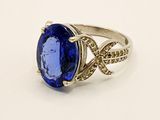 an oval blue sapphire and diamond ring on a white surface