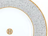 a white plate with a gold rim and a black and white pattern