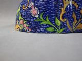 a close up of a blue hat with flowers on it