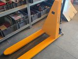 un chariot élévateur dans un entrepôt où se trouvent de nombreux cartons au sol