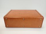 an image of a brown suitcase sitting on top of a white table