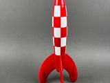 a red and white toy rocket sitting on top of a table