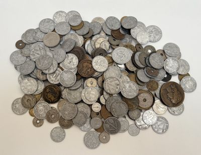 un tas d'argent et de pièces d'argent posé sur une surface blanche
