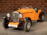 an orange and black car parked in front of a brick wall