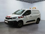 La camionnette blanche est garée dans une pièce blanche ornée d'une bande rouge et blanche.