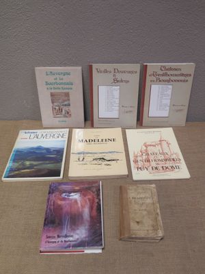 several books are sitting on a table in front of a wall