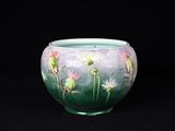 un vase vert orné de fleurs peintes sur fond noir