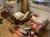 un homme debout dans une pièce où s'entassent des cartons par terre