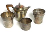 quatre tasses et une théière posées sur une table
