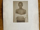 an old photo of a woman with a basket on a table