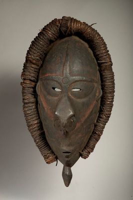 an african mask hanging on a wall in a room