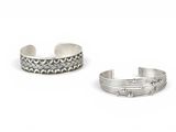 a pair of silver cuff bracelets on a white background