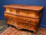a wooden chest of drawers on a rug in a room