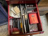 une boîte à outils rouge remplie d'outils divers, posée par terre