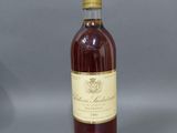 une bouteille de vin posée sur une table à côté d'un verre