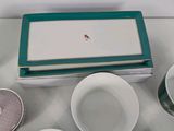 a white table topped with bowls and plates with a bird on it