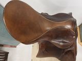a close up of a brown leather saddle on a stand