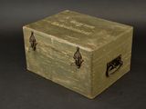 a small green box with metal handles on a black background