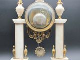 a clock that is sitting on a stand on a table