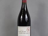 La bouteille de vin rouge est posée sur une table en verre.