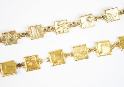 trois bracelets en or posés sur une surface blanche