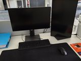 a computer desk with two monitors and a keyboard on it
